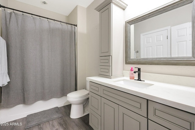 full bathroom featuring hardwood / wood-style flooring, vanity, toilet, and shower / bath combo with shower curtain