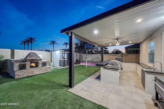 exterior space with an outdoor brick fireplace, exterior kitchen, and a patio