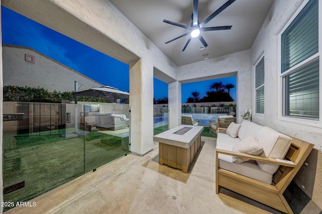 view of patio / terrace with an outdoor living space with a fire pit and ceiling fan