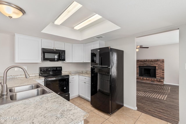 kitchen featuring light tile patterned floors, sink, white cabinetry, and black appliances