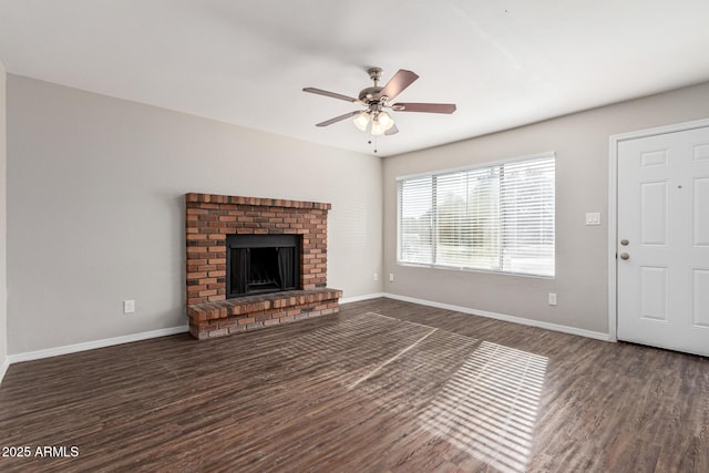 unfurnished living room featuring ceiling fan, dark hardwood / wood-style floors, and a brick fireplace