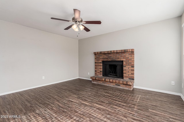 unfurnished living room with ceiling fan, dark wood-type flooring, and a brick fireplace