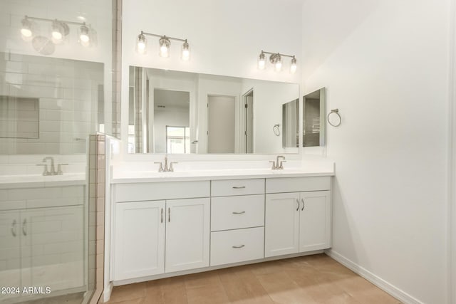 bathroom featuring a shower with door and vanity