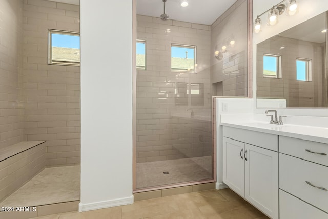 bathroom featuring vanity, tile patterned flooring, and tiled shower