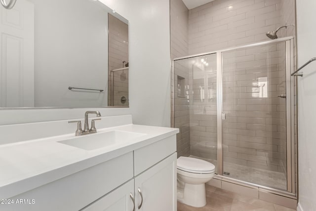 bathroom with vanity, toilet, walk in shower, and tile patterned flooring