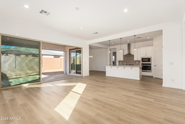 unfurnished living room with light hardwood / wood-style floors and sink