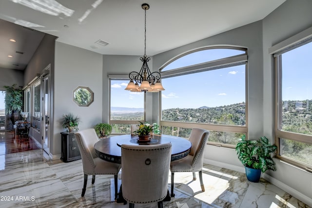 dining area with light tile patterned flooring and a notable chandelier