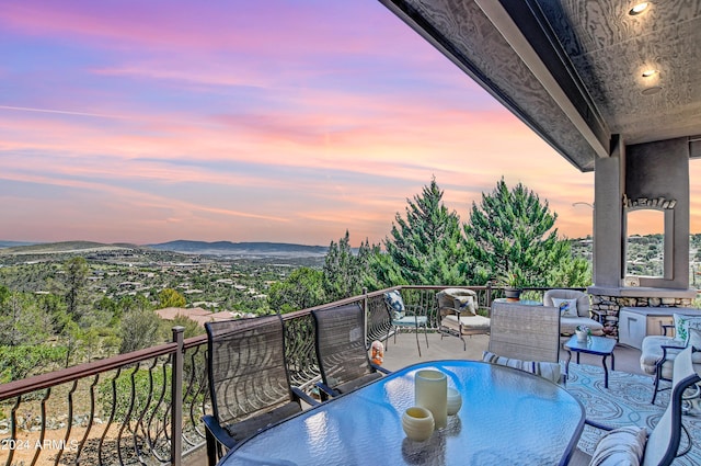 balcony at dusk featuring a mountain view