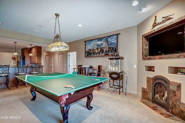recreation room with a fireplace and light carpet