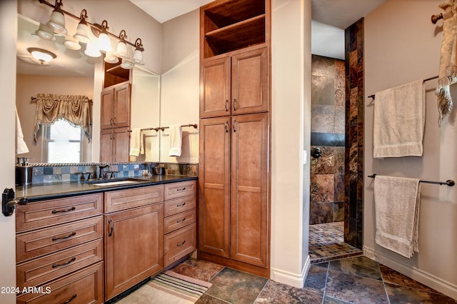 bathroom with tile patterned flooring, vanity, and tiled shower