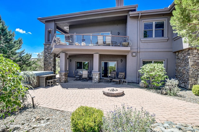 rear view of property featuring a patio and a balcony