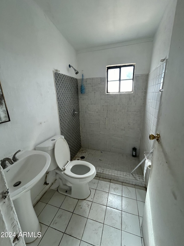 bathroom featuring toilet, tile patterned flooring, and tiled shower