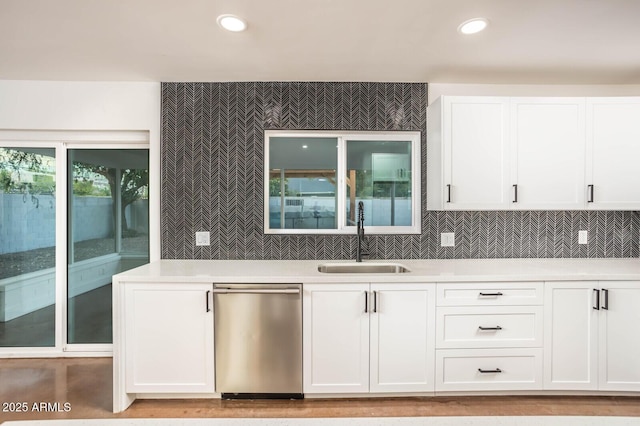 kitchen with backsplash, dishwasher, sink, and white cabinets