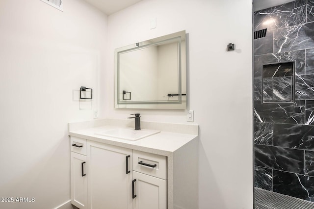 bathroom featuring vanity and tiled shower