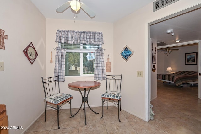 living area with ceiling fan and light tile patterned floors