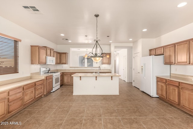 kitchen featuring white appliances, an island with sink, sink, hanging light fixtures, and a kitchen breakfast bar