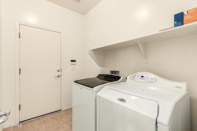 laundry area with light tile patterned floors and washer and clothes dryer