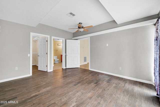 unfurnished bedroom with ceiling fan, connected bathroom, and dark hardwood / wood-style flooring