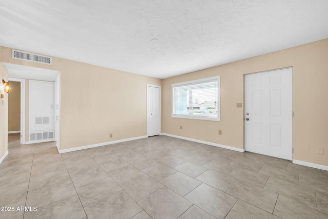 unfurnished room featuring light tile patterned floors and a textured ceiling