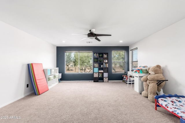 rec room with ceiling fan and carpet