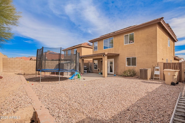 back of house with a trampoline, cooling unit, and a patio area