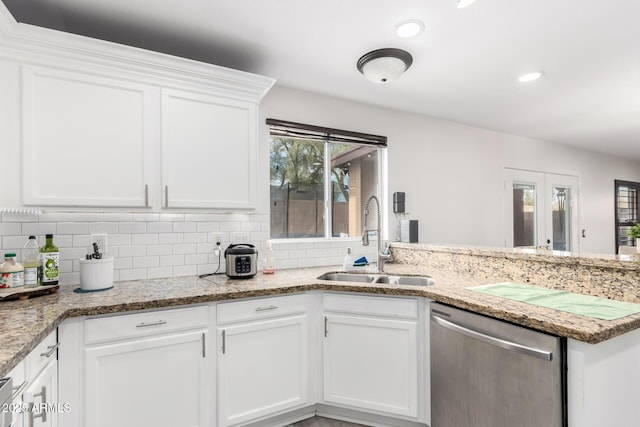 kitchen featuring dishwasher, sink, and white cabinets