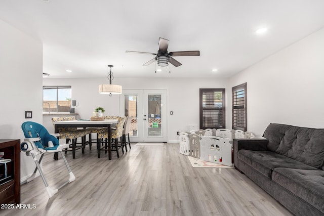 living room with french doors, ceiling fan, and light hardwood / wood-style flooring