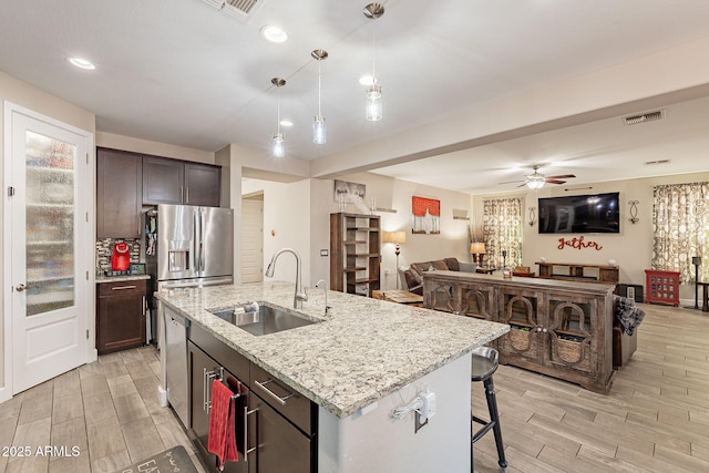 5012 S Girard St, Gilbert, AZ 85298 - kitchen with visible vents, a sink, open floor plan, dark brown cabinetry, and light wood finished floors