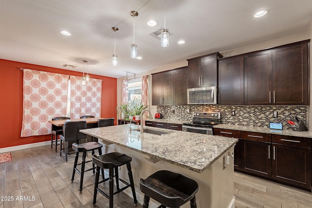 5012 S Girard St, Gilbert, AZ 85298 - kitchen featuring visible vents, a sink, appliances with stainless steel finishes, light wood-style flooring, and decorative backsplash