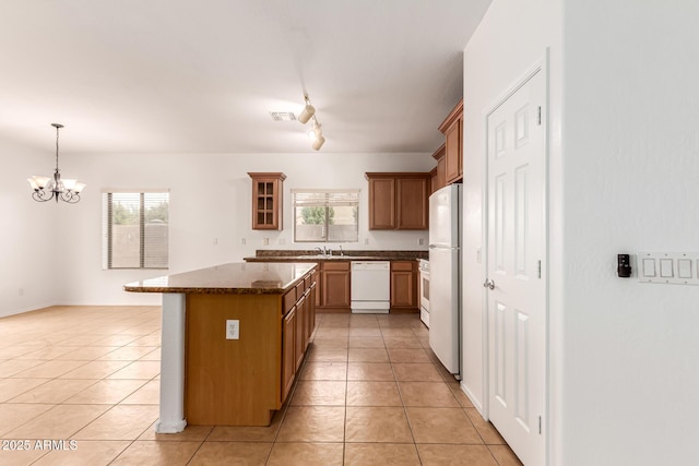 kitchen featuring pendant lighting, white appliances, sink, and light tile patterned floors