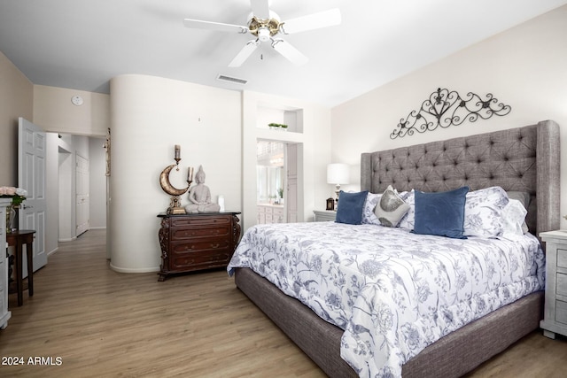 bedroom with baseboards, visible vents, wood finished floors, and a ceiling fan