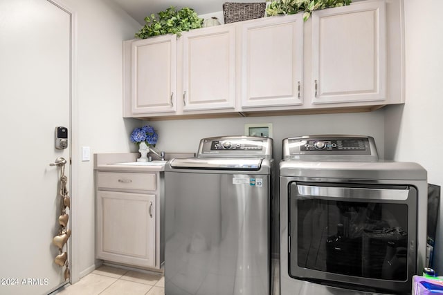 laundry area with light tile patterned flooring, separate washer and dryer, and cabinet space