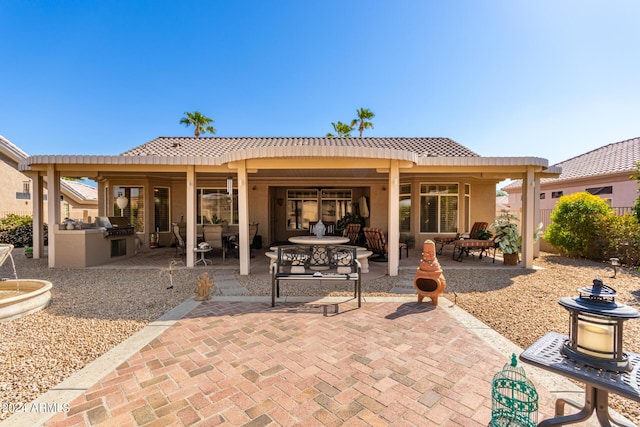 back of house with stucco siding, exterior kitchen, a patio area, and outdoor dining area