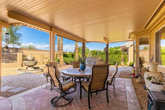 view of patio with a grill, exterior kitchen, a fenced backyard, and outdoor dining area