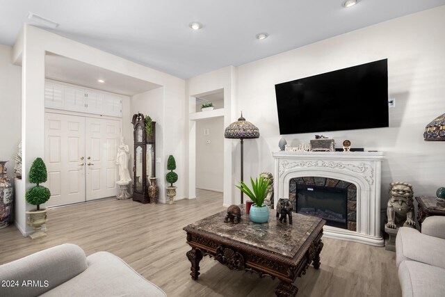 living room with wood finished floors, recessed lighting, a high end fireplace, and baseboards