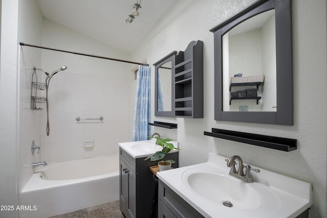 full bathroom featuring lofted ceiling, two vanities, a sink, and shower / bath combo with shower curtain