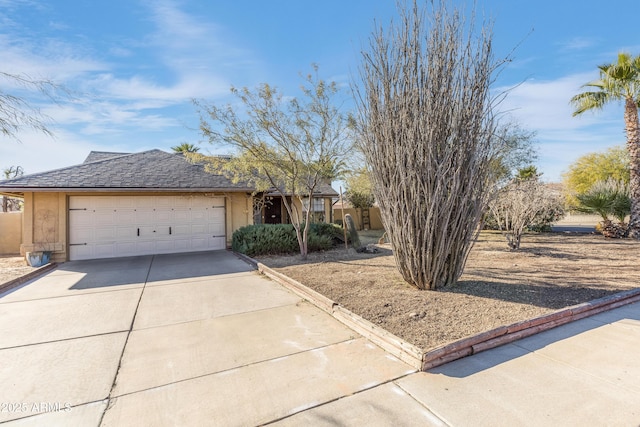 view of front of property with a garage, a shingled roof, concrete driveway, and stucco siding