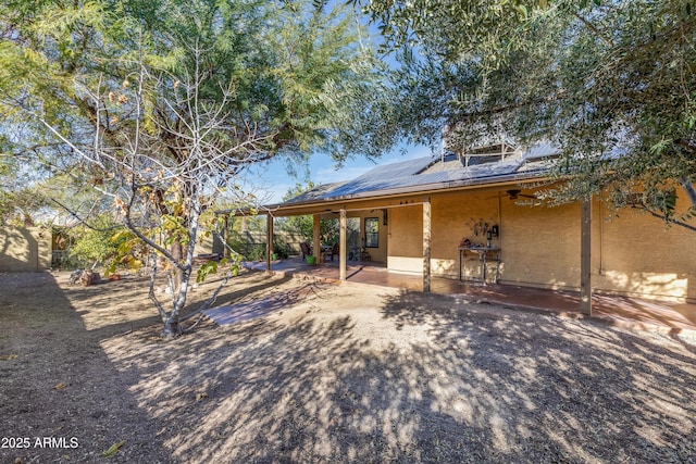 back of house featuring solar panels and a patio