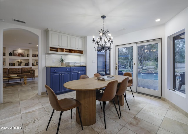 dining space with arched walkways, a notable chandelier, recessed lighting, visible vents, and baseboards