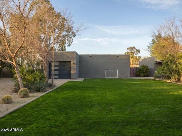 exterior space featuring fence, a lawn, and stucco siding