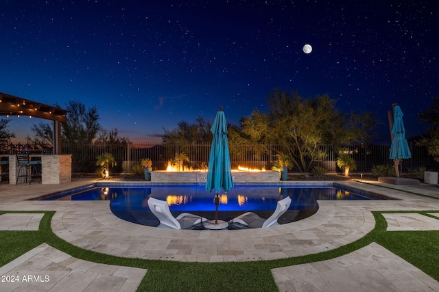 pool at dusk featuring a patio area and exterior bar