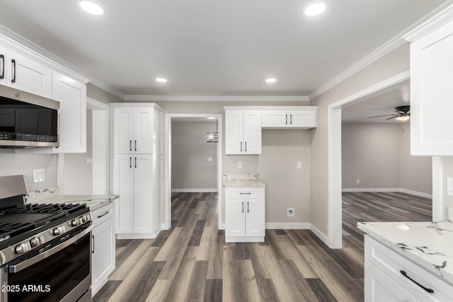 kitchen featuring dark wood-type flooring, baseboards, ornamental molding, white cabinets, and stainless steel appliances