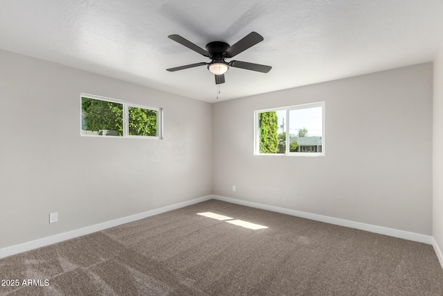 spare room with a ceiling fan, carpet, and baseboards