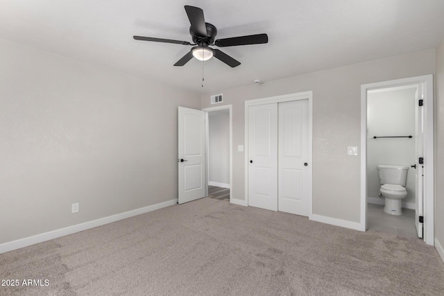 unfurnished bedroom featuring visible vents, ensuite bathroom, a closet, carpet, and baseboards