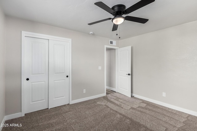 unfurnished bedroom featuring visible vents, ceiling fan, baseboards, carpet floors, and a closet