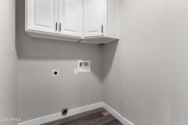 washroom featuring baseboards, cabinet space, electric dryer hookup, washer hookup, and dark wood-type flooring