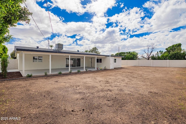 back of house featuring a patio, a fenced backyard, central AC, and stucco siding