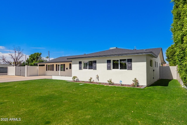 view of front of home with stucco siding, a front lawn, and fence