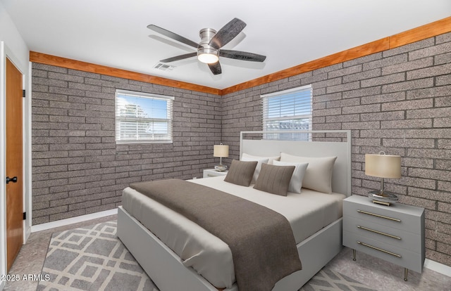 bedroom with brick wall, multiple windows, and ceiling fan