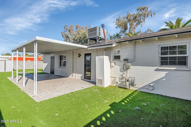 rear view of house with central AC, a patio area, and a yard